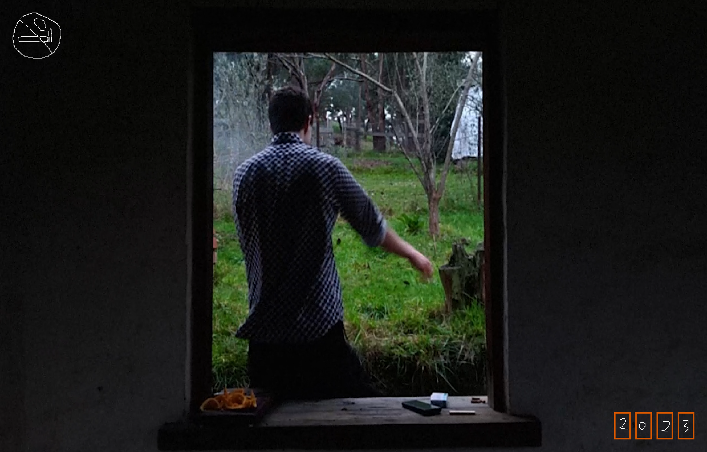 Fen's back, seen through a small window in a mud-brick wall